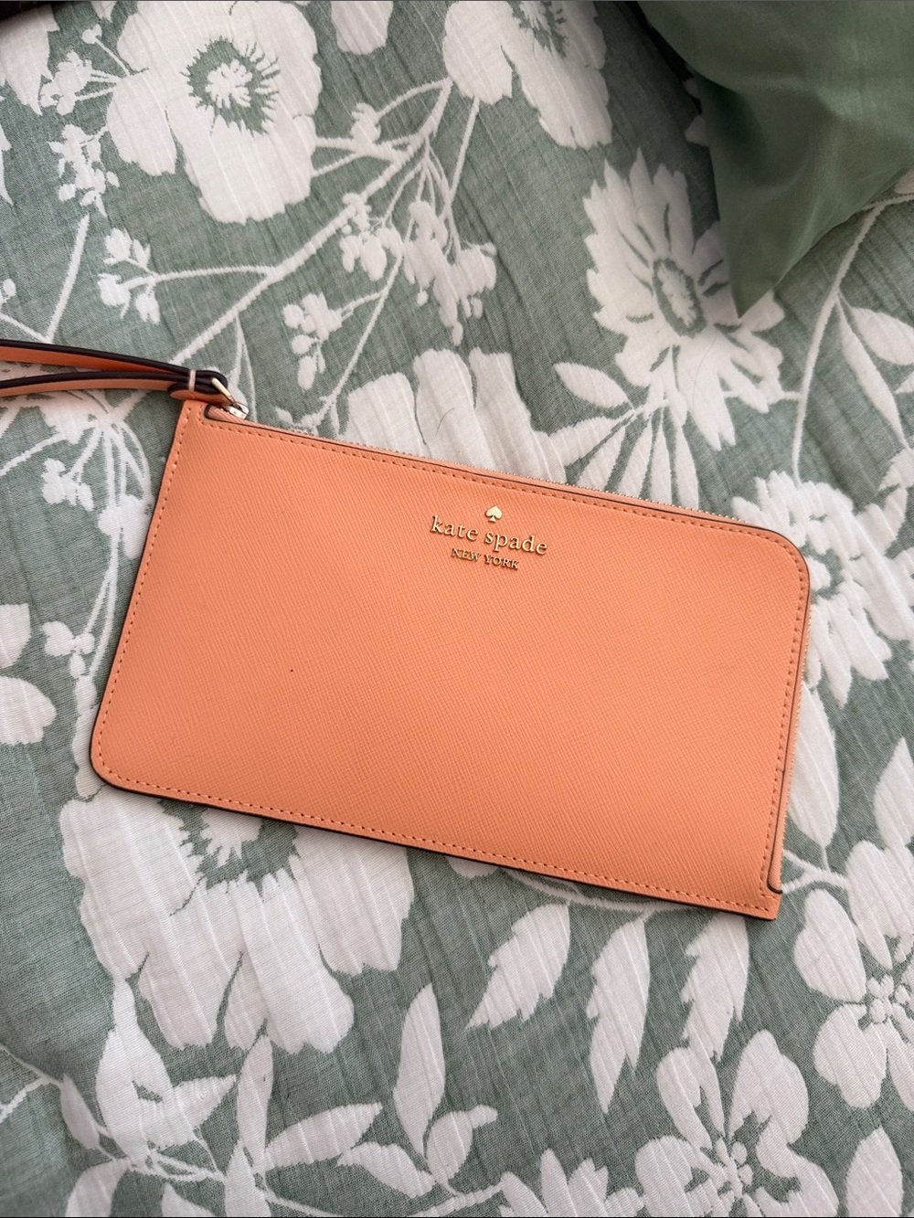 kate spade peach/orange leather wristlet with gold logo